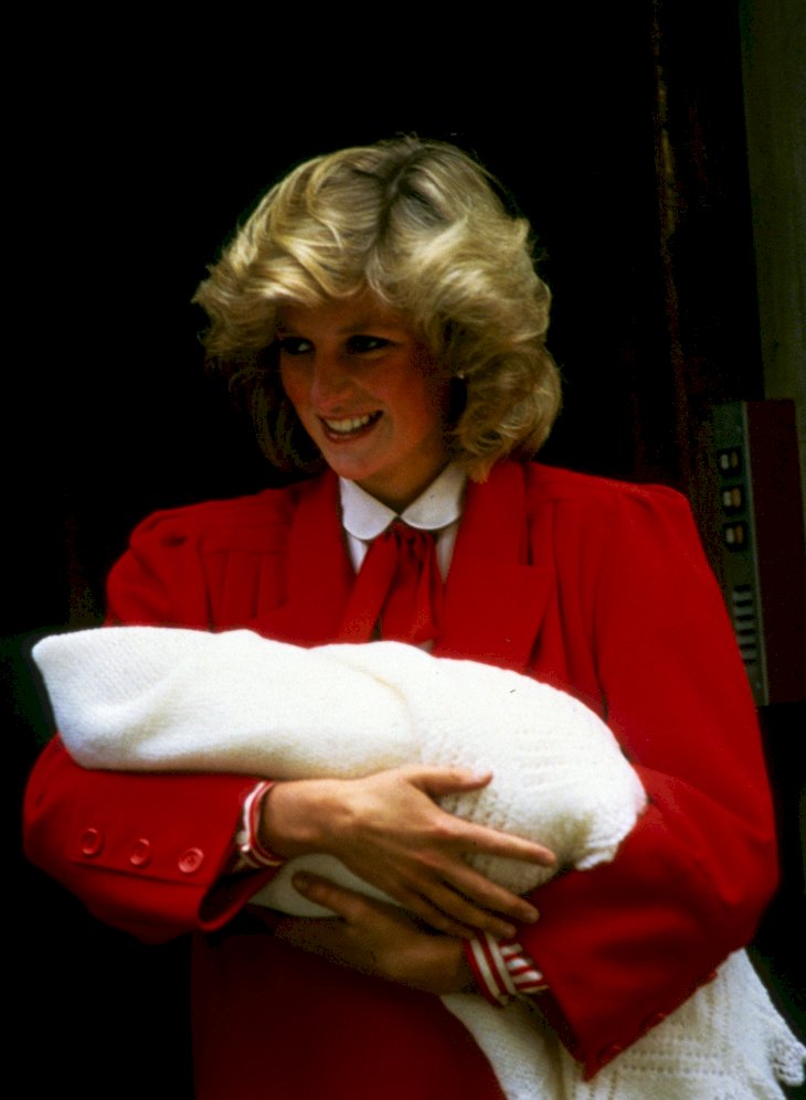 Image Credit: Getty Images / Princess Diana showing a newborn Prince Harry to the world.