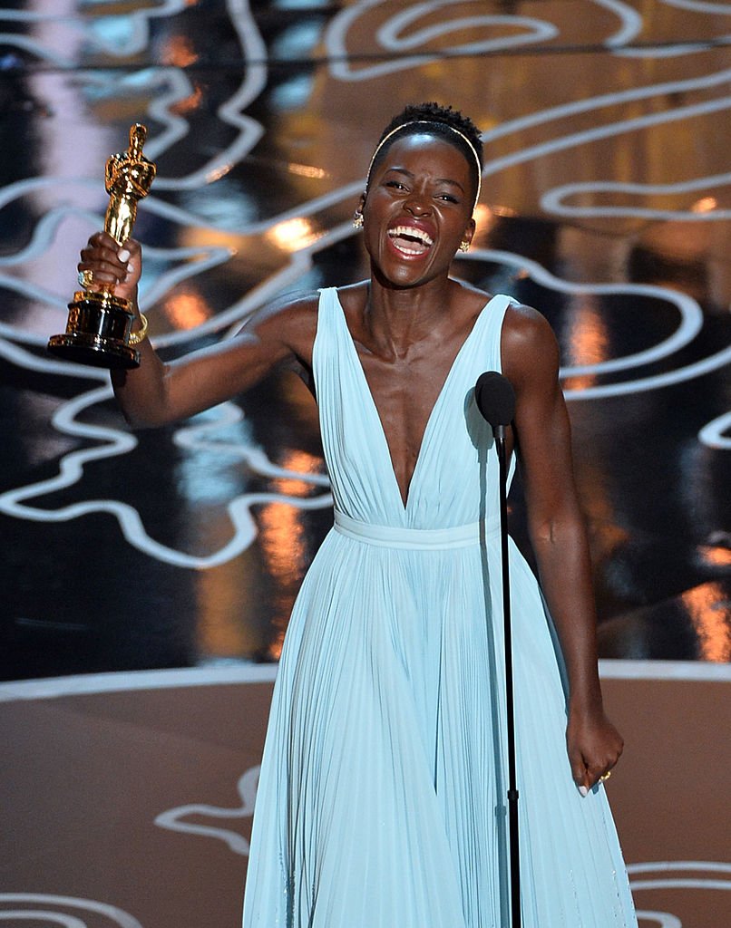 Image Credits: Getty Images / Kevin Winter | Actress Lupita Nyong'o accepts the Best Performance by an Actress in a Supporting Role award for '12 Years a Slave'