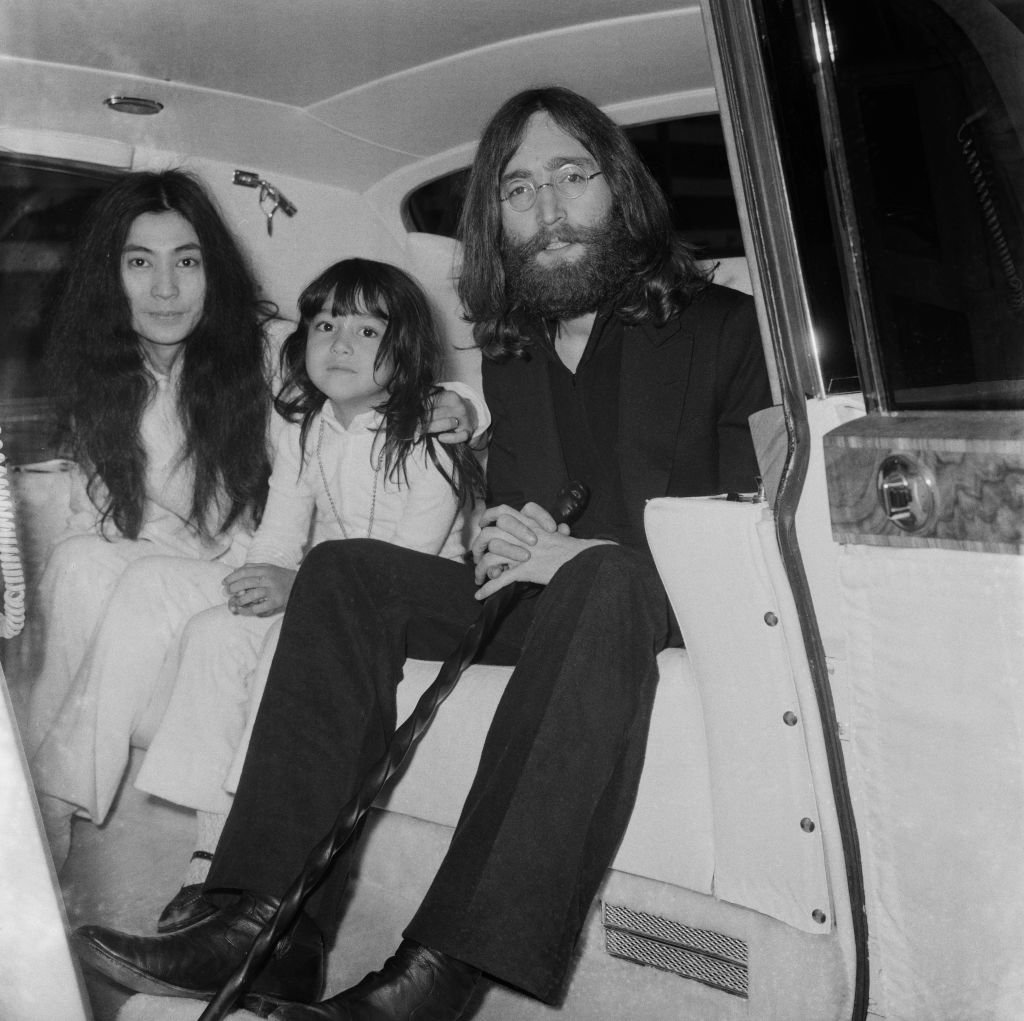 Image Credits: Getty Images / George Stroud / Daily Express / Hulton Archive | Japanese multimedia artist, singer, songwriter, and peace activist Yoko Ono with her daughter Kyoko Chan Cox and her husband English singer, songwriter, and peace activist John Lennon (1940 -1980) of The Beatles, at Heathrow Airport, London, UK, 7th June 1969.