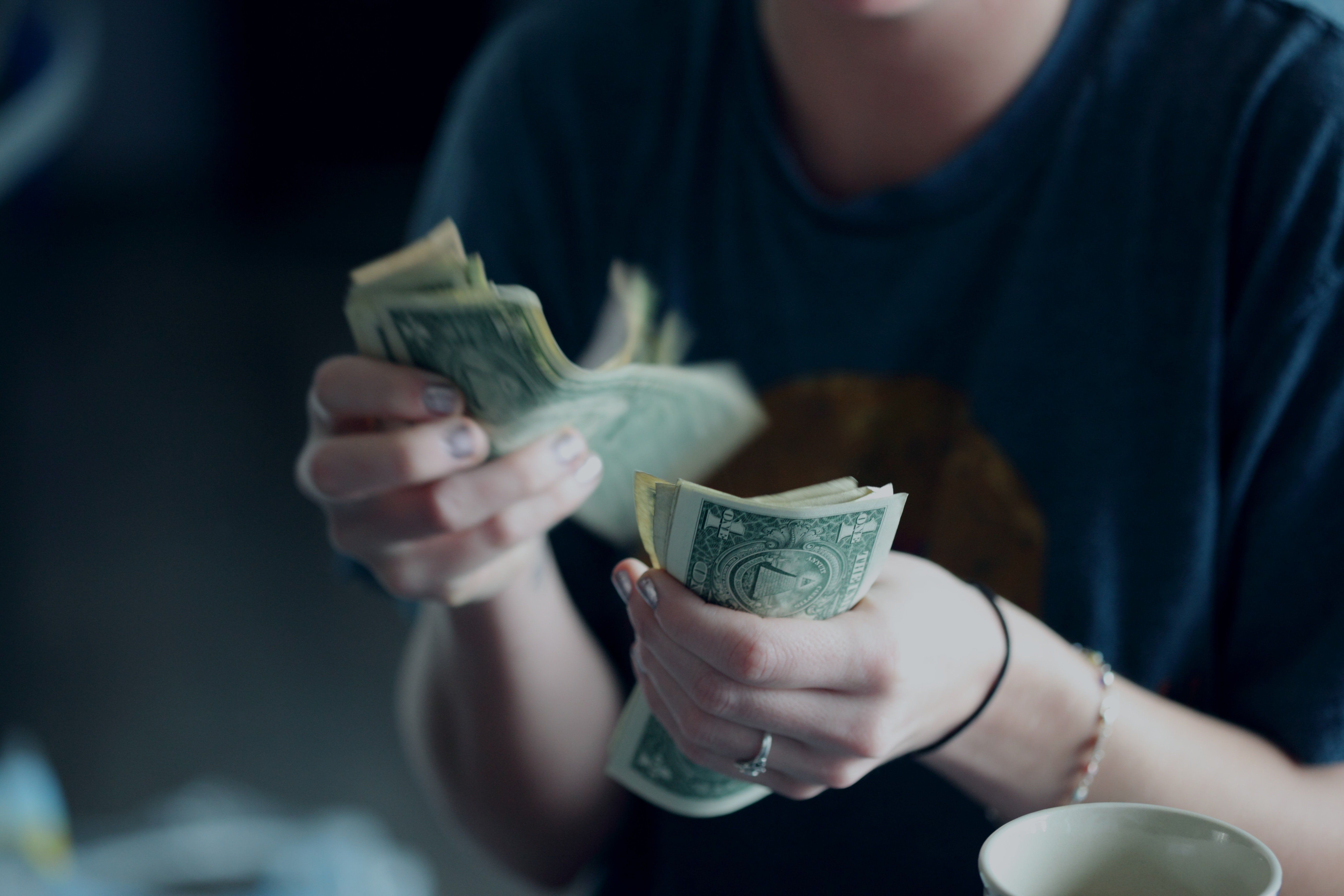 Counting out money for the bill | Unsplash