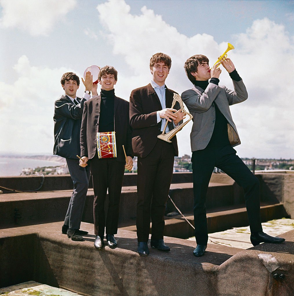 Image Credits: Getty Images / Michael Ochs Archives | Rock and roll band "The Beatles" pose for a portrait in circa 1964 in England. (L-R) George Harrison, John Lennon, Ringo Starr, Paul McCartney.