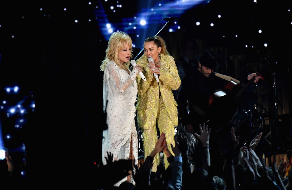 Image Credits: Getty Images / Jeff Kravitz / FilmMagic | Dolly Parton (L) and Miley Cyrus perform onstage during the 61st Annual GRAMMY Awards at Staples Center on February 10, 2019 in Los Angeles, California. Image Credits: Getty Images / Jeff Kravitz / FilmMagic | Dolly Parton (L) and Miley Cyrus perform onstage during the 61st Annual GRAMMY Awards at Staples Center on February 10, 2019 in Los Angeles, California.