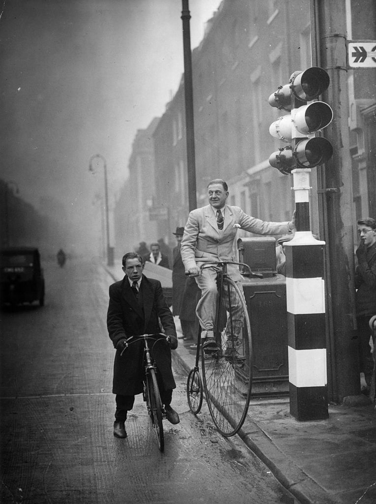 16th February 1938: Mr C A Denny, a former Olympic cyclist stops at traffic lights whilst riding a 52-year-old penny farthing to the London offices of the National Cyclists' Union. Image Source: Getty Images 16th February 1938: Mr C A Denny, a former Olympic cyclist stops at traffic lights whilst riding a 52-year-old penny farthing to the London offices of the National Cyclists' Union. Image Source: Getty Images