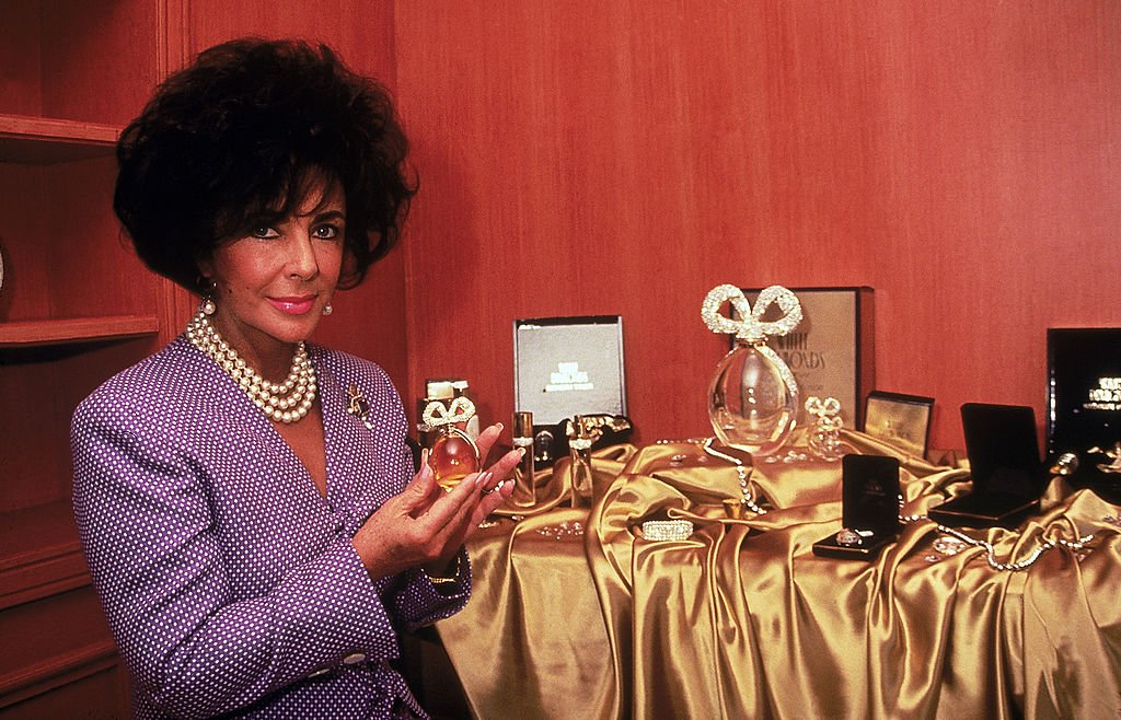 Image Credit: Getty Images / Actress Elzabeth Taylor holding bottle of her perfume.